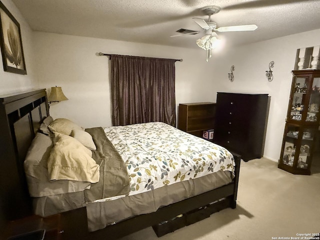 carpeted bedroom featuring ceiling fan and a textured ceiling