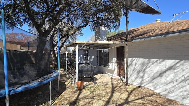 view of yard featuring a trampoline and a patio