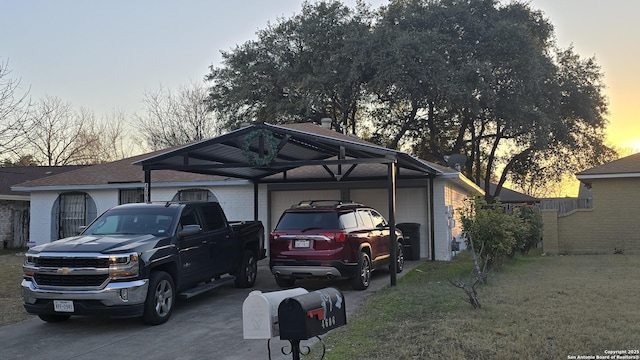 parking at dusk featuring a yard and a carport