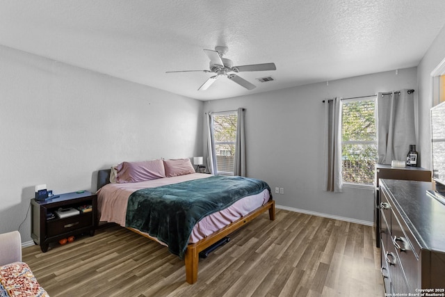 bedroom featuring a textured ceiling, ceiling fan, and dark hardwood / wood-style flooring