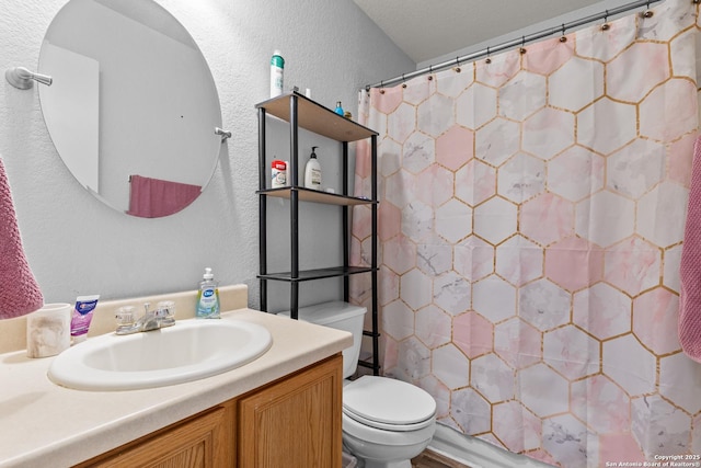 bathroom featuring toilet, vanity, and walk in shower