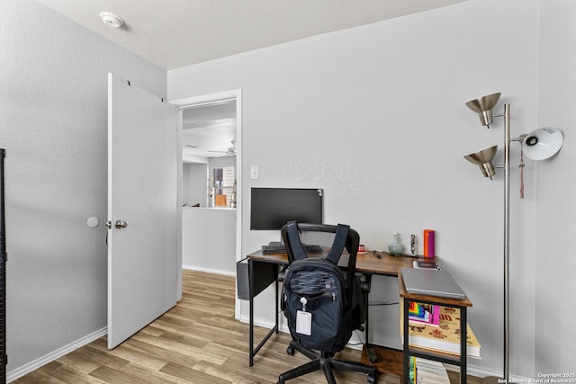 office with light wood-type flooring, ceiling fan, and a textured ceiling