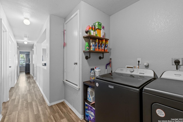 laundry area featuring separate washer and dryer, a textured ceiling, and light hardwood / wood-style floors