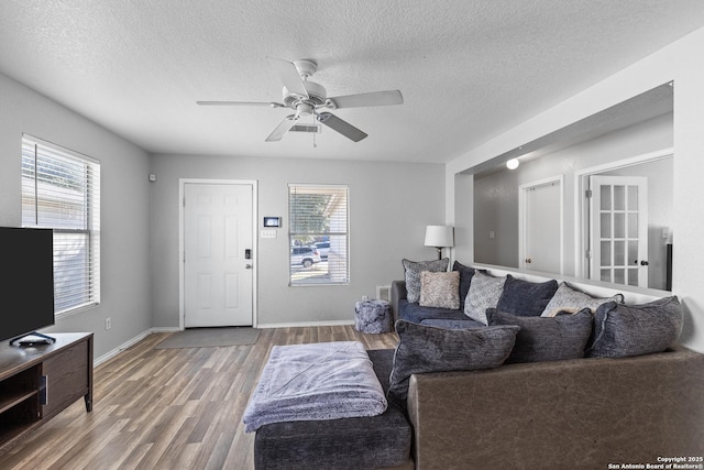 living room featuring hardwood / wood-style flooring, a textured ceiling, and ceiling fan