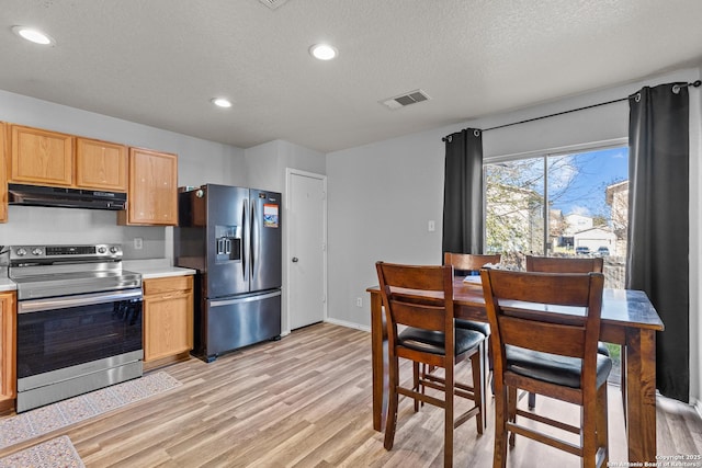 kitchen featuring a textured ceiling, appliances with stainless steel finishes, and light hardwood / wood-style flooring