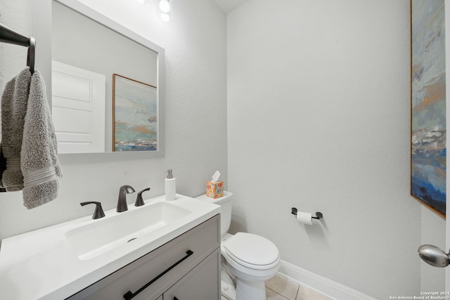 bathroom with toilet, vanity, and tile patterned floors