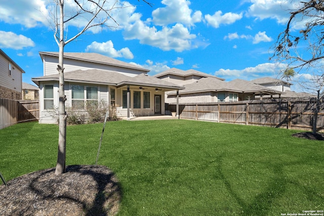 rear view of property with a lawn, ceiling fan, and a patio