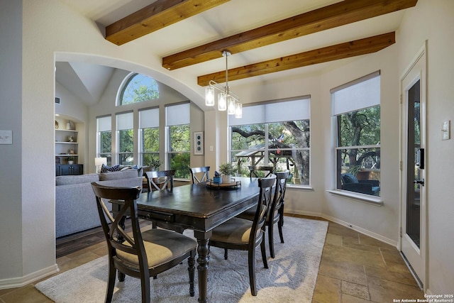 dining area with built in features, a chandelier, and beamed ceiling