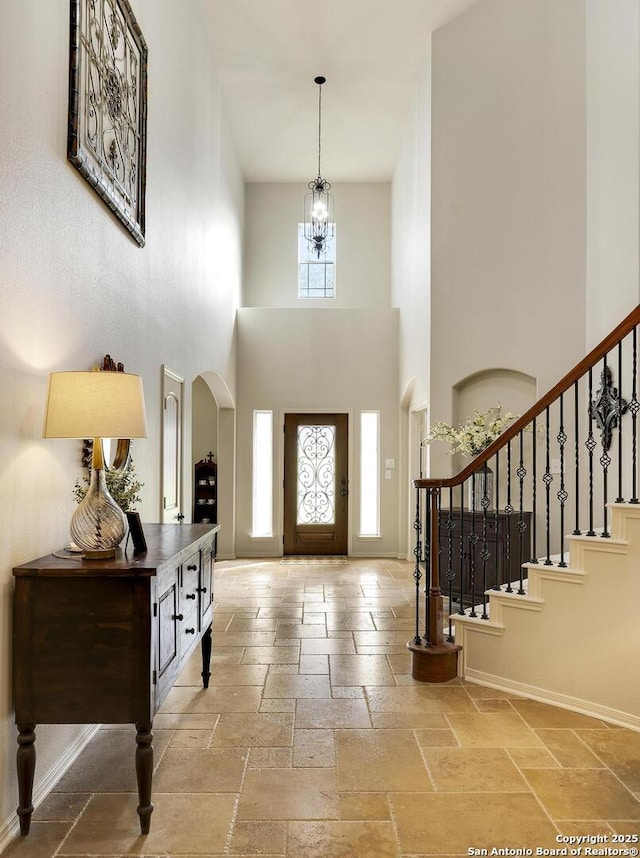 foyer entrance featuring a high ceiling and a notable chandelier