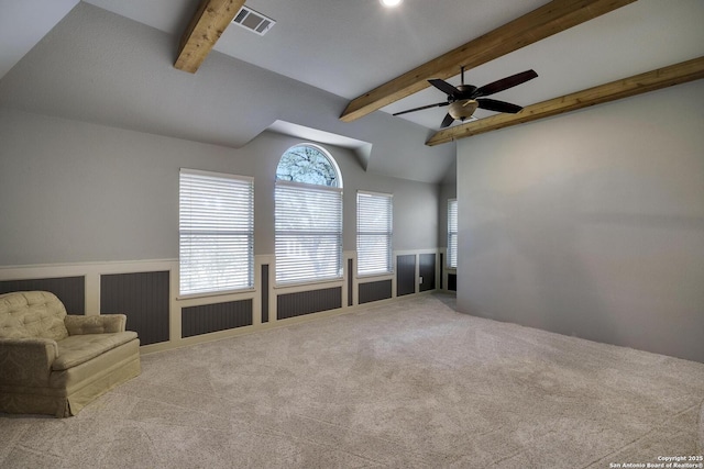 unfurnished living room with ceiling fan, light carpet, and vaulted ceiling with beams