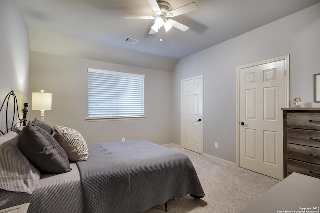 bedroom with ceiling fan, light colored carpet, and vaulted ceiling