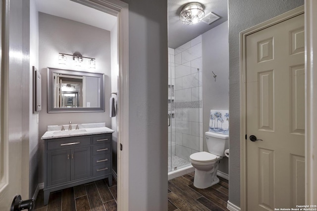 bathroom featuring vanity, walk in shower, and toilet