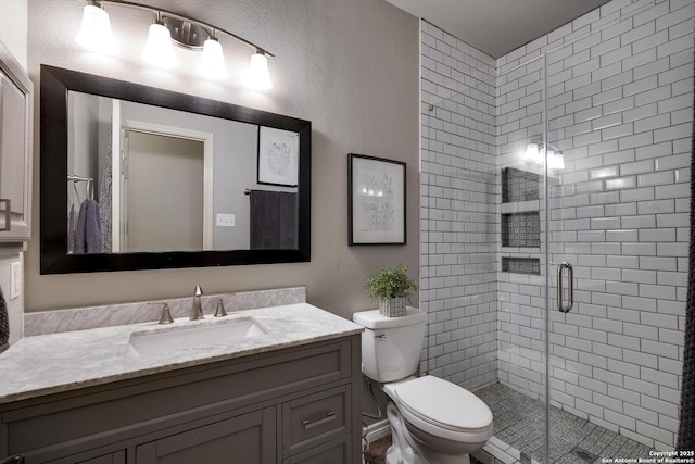 bathroom with vanity, an enclosed shower, and toilet