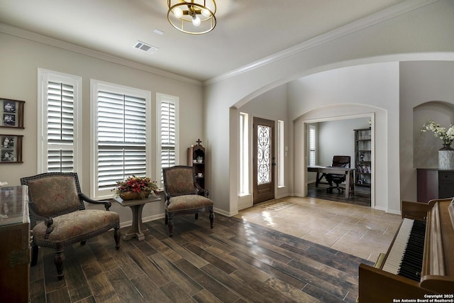 entrance foyer with crown molding, wood-type flooring, and a chandelier