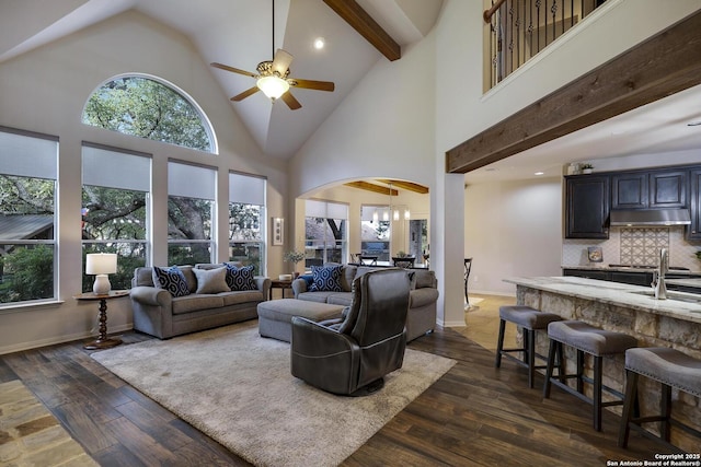 living room featuring high vaulted ceiling, dark hardwood / wood-style flooring, ceiling fan with notable chandelier, and beam ceiling