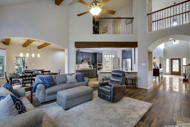 living room featuring a wealth of natural light, dark hardwood / wood-style floors, and beamed ceiling