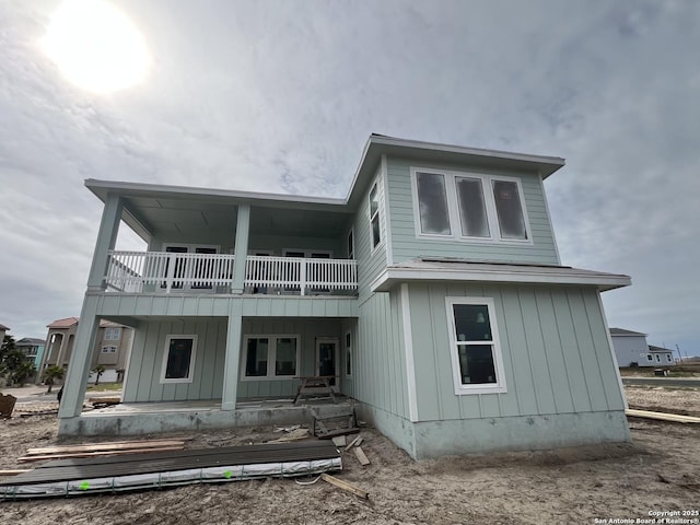 back of property featuring a porch and a balcony