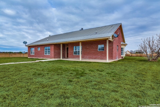 back of property with a patio area and a lawn