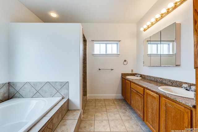 bathroom with tiled bath, tile patterned flooring, and vanity