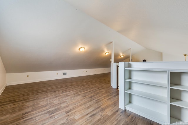 bonus room with wood-type flooring, built in features, and lofted ceiling