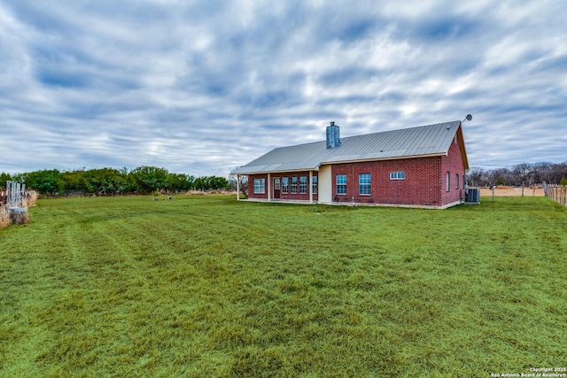 back of house featuring a lawn and central AC unit