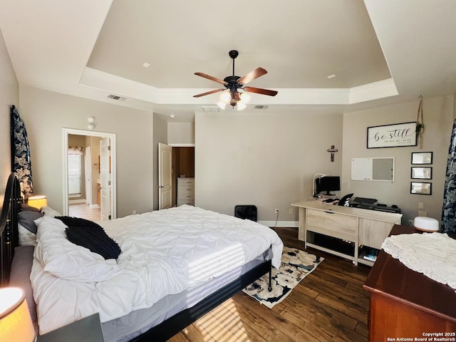 bedroom with dark wood-type flooring, ceiling fan, and a raised ceiling