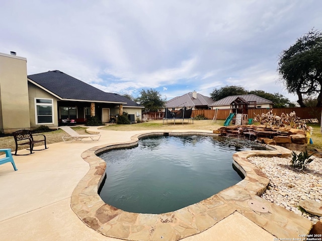 view of pool featuring a trampoline, a patio area, and a playground