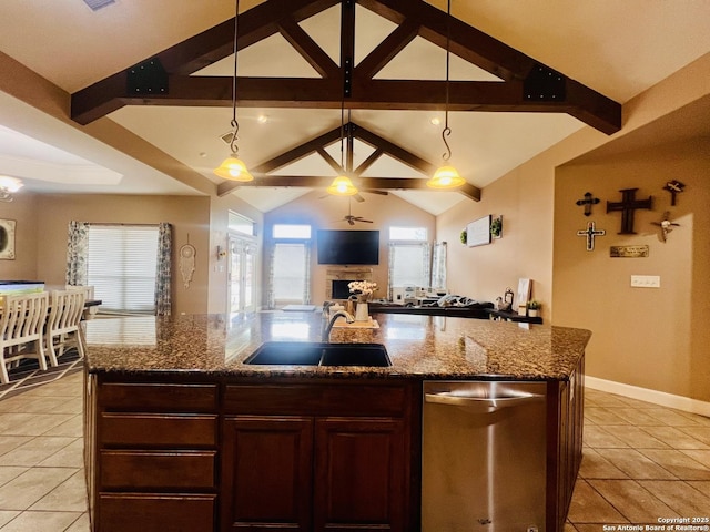 kitchen featuring sink, a healthy amount of sunlight, pendant lighting, and an island with sink