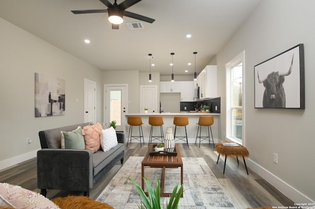 living room with ceiling fan and dark hardwood / wood-style floors