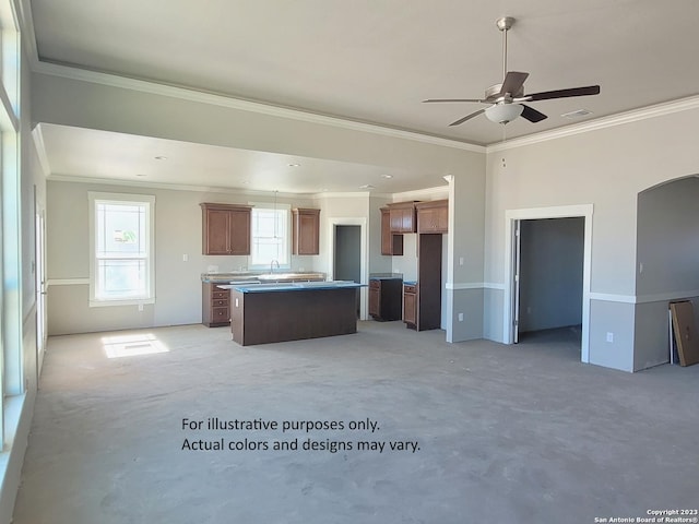 kitchen with ceiling fan, sink, ornamental molding, and a center island