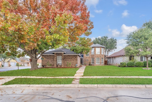 view of front of property featuring a front lawn and brick siding