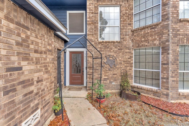 property entrance featuring brick siding