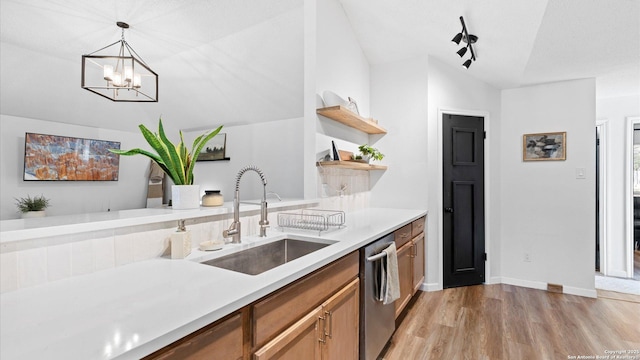 kitchen with dishwasher, sink, hanging light fixtures, a chandelier, and light wood-type flooring