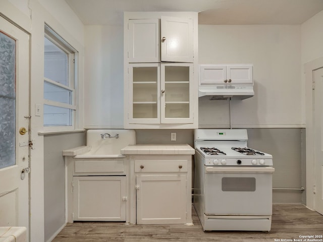 kitchen featuring gas range gas stove, light wood-type flooring, and white cabinetry