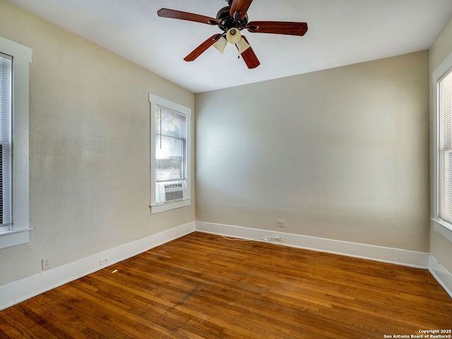 spare room featuring ceiling fan, plenty of natural light, cooling unit, and wood-type flooring