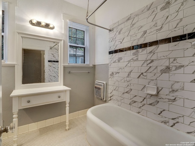 bathroom featuring tiled shower / bath, heating unit, and tile patterned floors