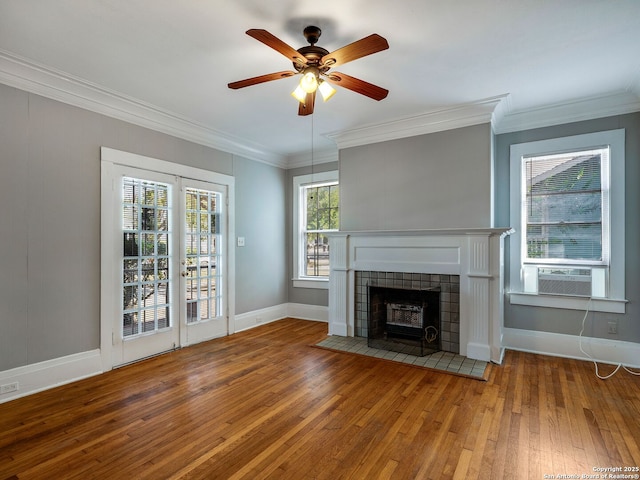 unfurnished living room with ceiling fan, hardwood / wood-style floors, cooling unit, a tiled fireplace, and ornamental molding