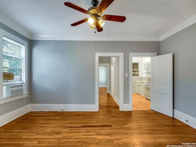 empty room featuring ceiling fan, cooling unit, crown molding, and light hardwood / wood-style floors