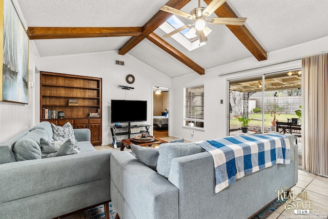 living room with ceiling fan, a textured ceiling, lofted ceiling with beams, and light tile patterned flooring