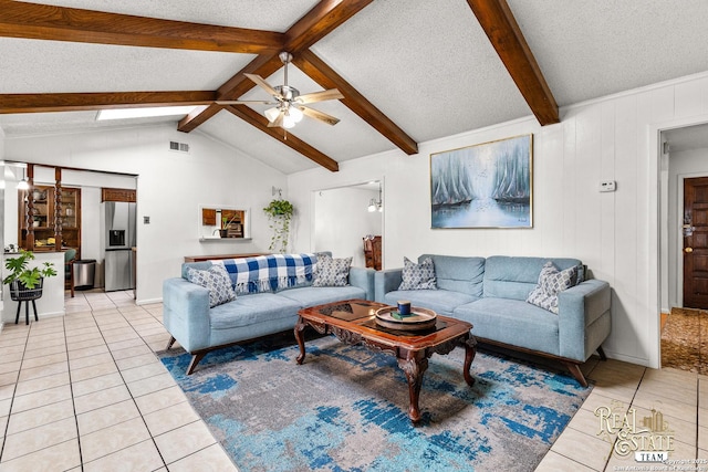 tiled living room with ceiling fan, lofted ceiling with beams, and a textured ceiling