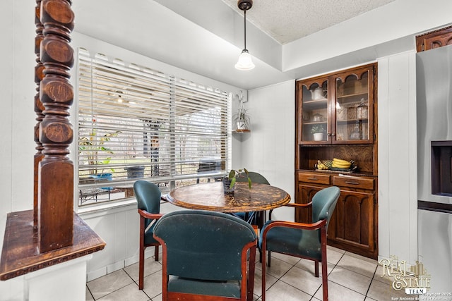 dining space with light tile patterned floors and a textured ceiling