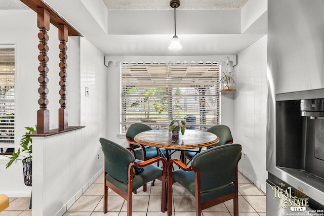 dining space with a textured ceiling and light tile patterned floors