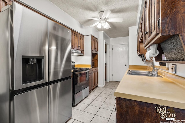 kitchen featuring a textured ceiling, appliances with stainless steel finishes, sink, ceiling fan, and light tile patterned floors