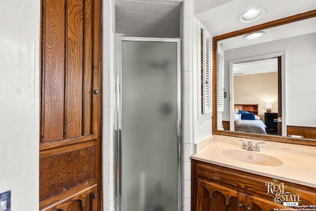 bathroom featuring a shower with door and sink