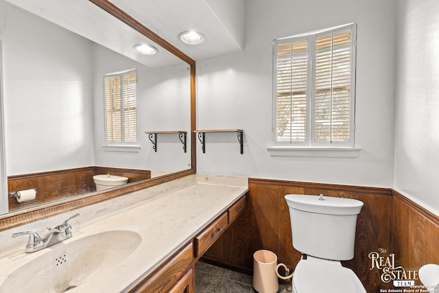 bathroom featuring wood walls, tile patterned floors, plenty of natural light, and vanity