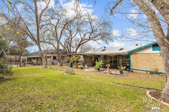 rear view of house featuring a patio area and a lawn