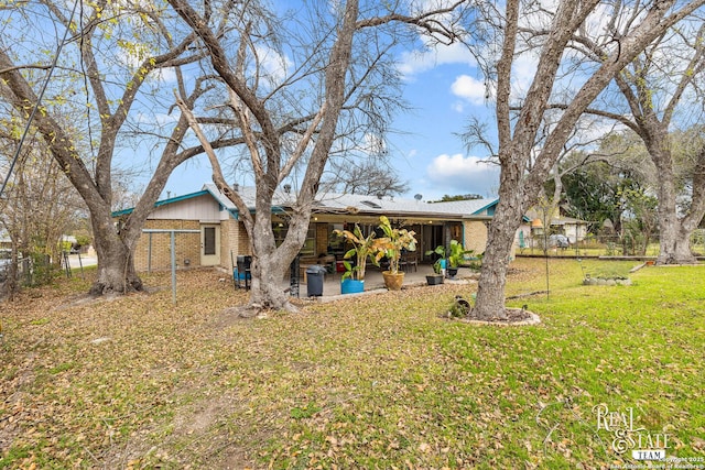 back of house featuring a lawn and a patio