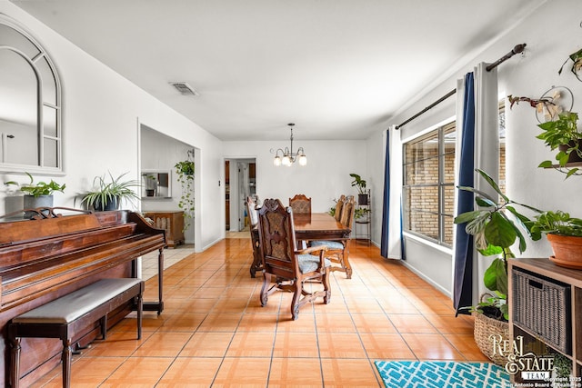 tiled dining area featuring an inviting chandelier