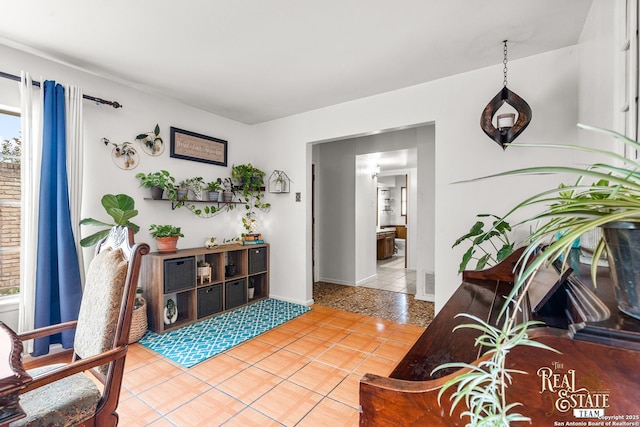 living area with light tile patterned floors and a healthy amount of sunlight