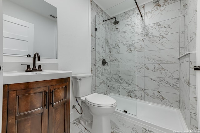 bathroom with toilet, vanity, and a tile shower